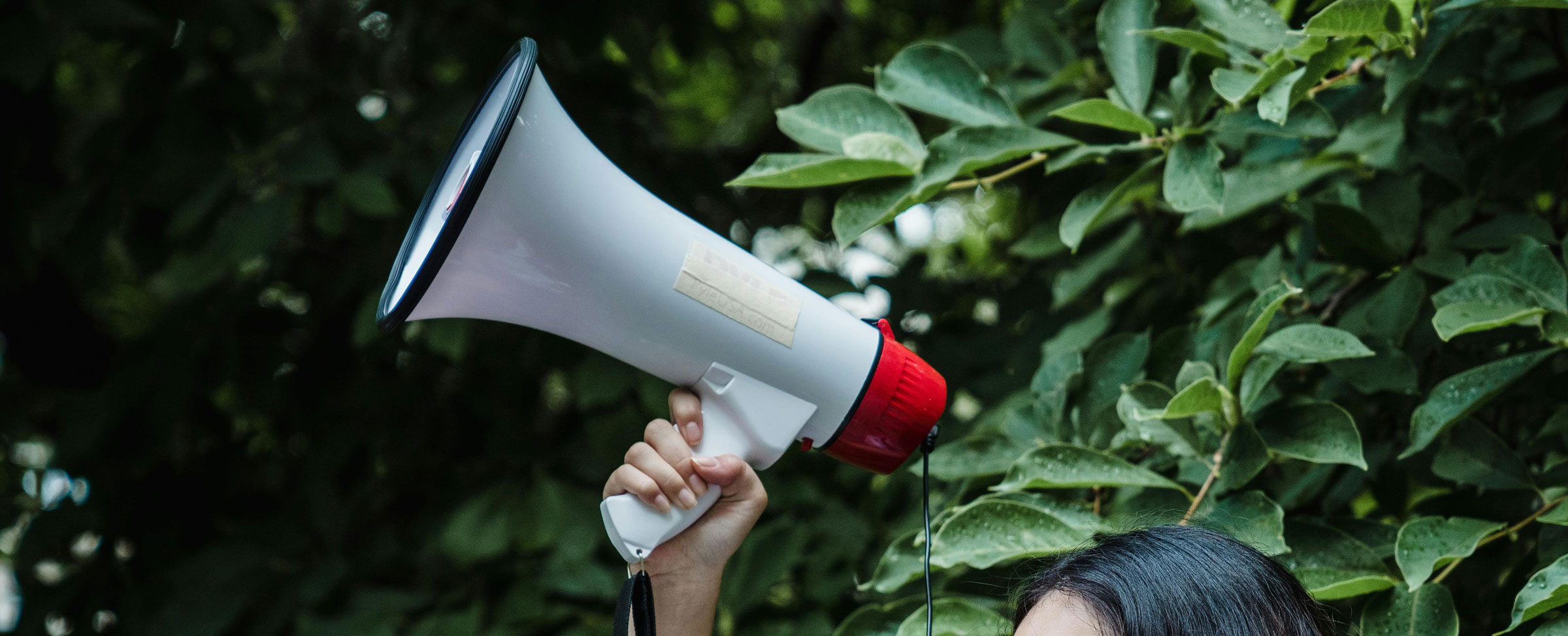 Hand holding up a megaphone.